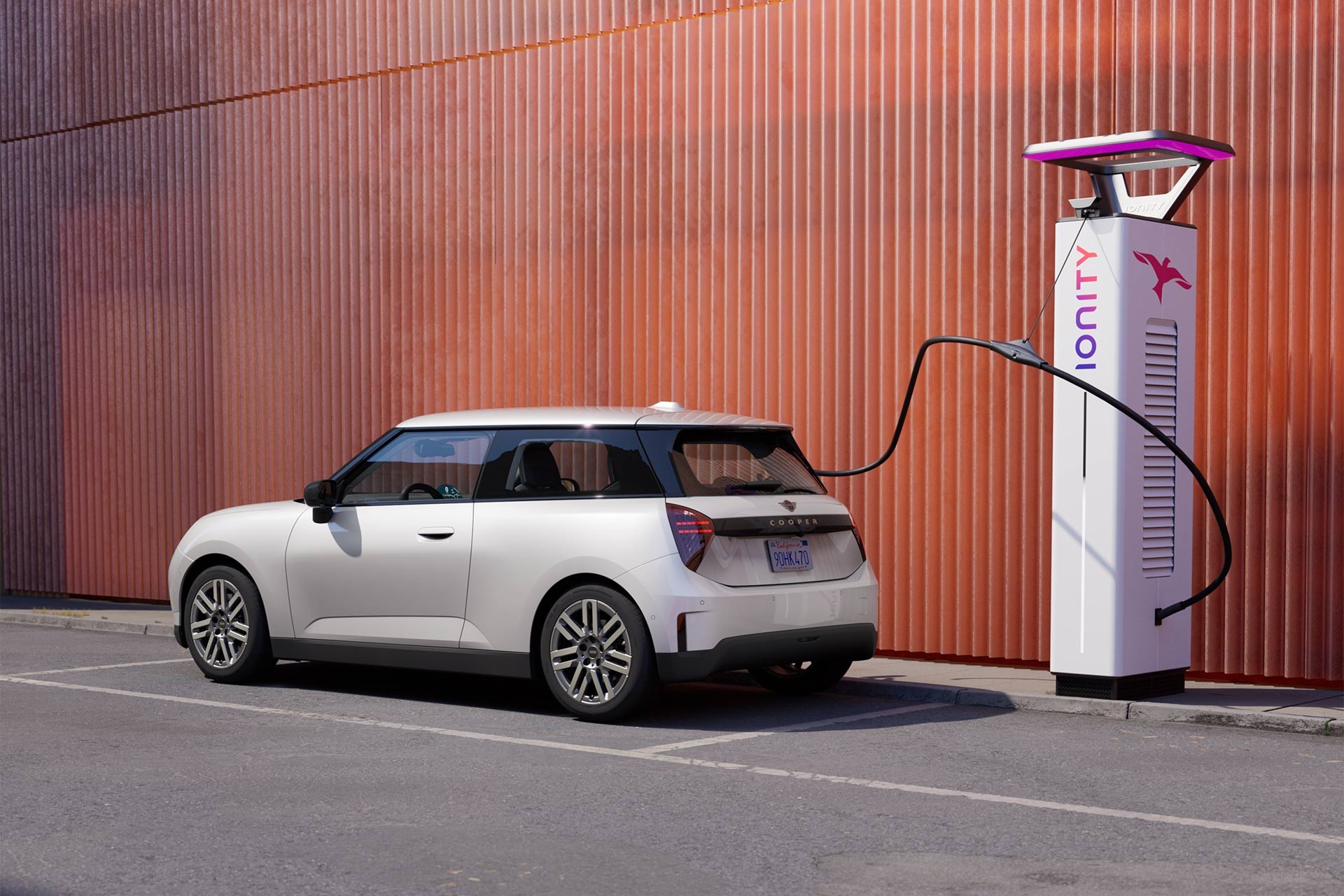 Man charging parked white Nanuq white MINI Electric